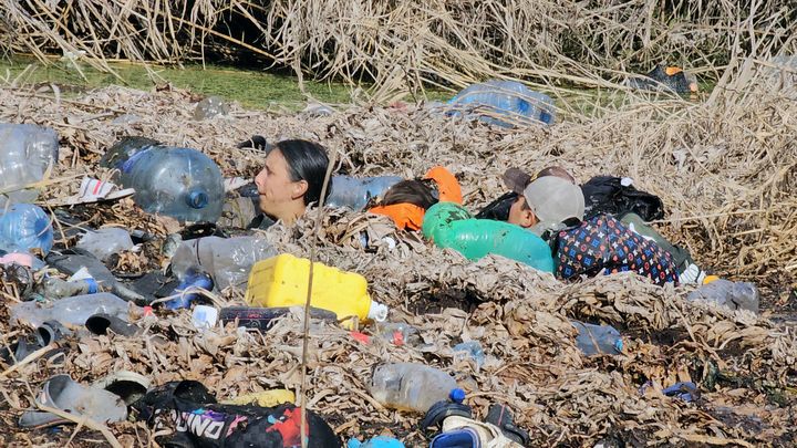 Des migrants traversent le Rio Grande au milieu des détritus, à Matamoros, à la frontière entre le Mexique et les Etats-Unis, le 21 décembre 2023. (ANGEL DOMINGUEZ / AFP)