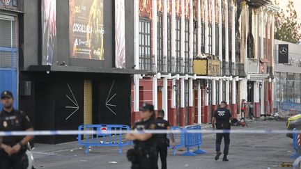 Des policiers se tiennent devant la discothèque où sont mortes 13 personnes dans un incendie à Murcie (Espagne), le 2 octobre 2023. (JOSE JORDAN / AFP)