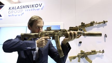 Le ministre de l'Industrie et du Commerce&nbsp;russe, Denis Manturov, se montre en train d'essayer une arme sur le stand du groupe&nbsp;Kalashnikov lors de l'International Defence Exhibition à Abu Dhabi le 22 février 2015. Kalashnikov&nbsp;dit&nbsp;se concentrer sur ses marchés au Moyen-Orient et en Afrique et diversifier sa gamme de produits pour compenser l'impact des sanctions occidentales qui touchent la Russie.&nbsp; (REUTERS - STRINGER . / X80002)