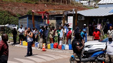 Des Mahorais font la queue à une station essence, le 20 décembre 2024 à Pamandzi à Mayotte. (LUDOVIC MARIN / AFP)