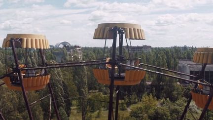 Capture d'&eacute;cran d'une vid&eacute;o montrant la grande roue de Pripiat (Ukraine) et, au loin, le chantier de la centrale nucl&eacute;aire de Tchernobyl. (DANNY COOKE / VIMEO)