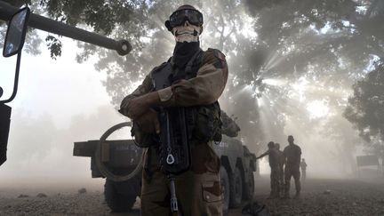 Un soldat fran&ccedil;ais portant un foulard &agrave; t&ecirc;te de mort pose pr&egrave;s d'un blind&eacute; &agrave; Niono&nbsp;(Mali), le 20 janvier 2013. (ISSOUF SANOGO / AFP)