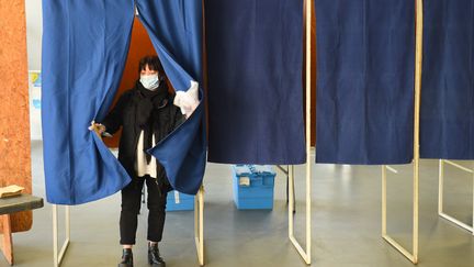 Une femme avec un masque en sortant d'un isoloir le 15 mars 2020 à Bordeaux.&nbsp; (NICOLAS TUCAT / AFP)