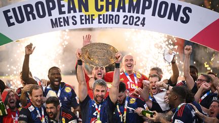 Le capitaine de l'équipe de France, Luka Karabatic, soulève le trophée de champion d'Europe au milieu de ses coéquipiers, à l'issue de la finale de l'Euro entre la France et le Danemark, le 28 janvier 2024 à Cologne (Allemagne). (KIRILL KUDRYAVTSEV / AFP)