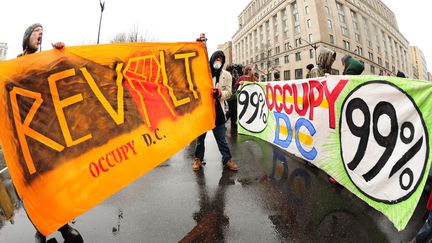 Des manifestants du mouvement Occupy DC bloquent une rue &agrave; Washington au cours d'une s&eacute;rie d'actions pour "reprendre le Capitole", le 7 d&eacute;cembre 2011.&nbsp; (KAREN BLEIER / AFP)