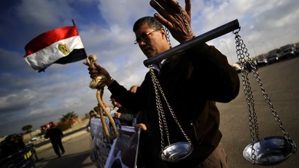 Un Egyptien tient une balance et une corde au Caire lors du proc&egrave;s d'Hosni Moubarak, le 28 d&eacute;cembre 2011. (FILIPPO MONTEFORTE/AFP)