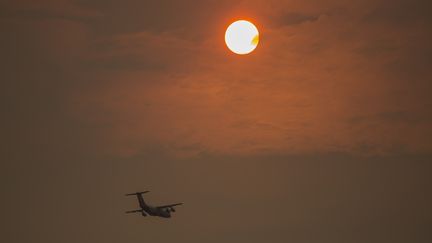 Un avion participant &agrave; la lutte contre le feu lors d'un coucher de soleil nuageux pr&egrave;s de San Andr&eacute;as, en Californie, le 13 septembre 2015. (DAVID MCNEW / GETTY IMAGES NORTH AMERICA)