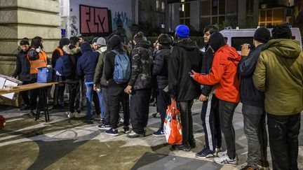 Des réfugiés lors d'une distribution au niveau du métro Stalingrad, à Paris, en janvier 2023. (JULIEN MATTIA / AFP)