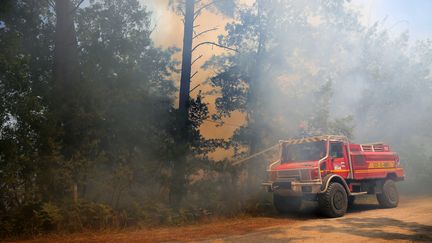 Les pompiers tentent d'éteindre l'incendie près de Landiras (Gironde), le 13 juillet 2022. (LAURENT THEILLET / MAXPPP)