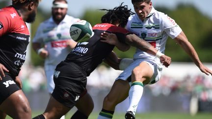 Le demi de mêlée de la Section Paloise Thibault Daubagna plaqué par un joueur toulonnais. (NICOLAS TUCAT / AFP)