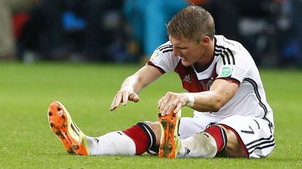 Le milieu de terrain Bastian&nbsp;Schweinsteiger, victime de crampes, s'&eacute;tire sur le terrain lors des prolongations du match Allemagne-Alg&eacute;rie, le 30 juin 2014, &agrave; Porto Alegre (Br&eacute;sil). (DARREN STAPLES / REUTERS )