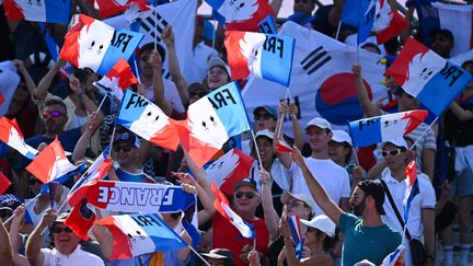 Les supporters français brandissent des drapeaux dans les tribunes du Grand Palais, pour les épreuves d'escrime, le 27 juillet 2024. (PHILIPPE MONTIGNY / KMSP / AFP)