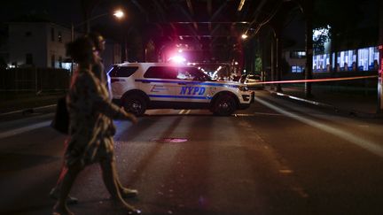 Une voiture de police boucle la scène de crime, dans le Queens, à New York, le 13 août 2016. (KENA BETANCUR / AFP)