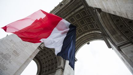 Un drapeau tricolore g&eacute;ant sous l'Arc de triomphe, &agrave; Paris, le 8 mai 2015, pour les comm&eacute;morations du 70e anniversaire de la capitulation de l'Allemagne nazie. (IAN LANGSDON / AFP)