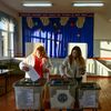 Deux personnes votent durant l'élection présidentielle et un référendum sur l'adhésion de la Moldavie à l'Union européenne dans un bureau de vote du village d'Hirbovat (Moldavie), le 20 octobre 2024. (DANIEL MIHAILESCU / AFP)