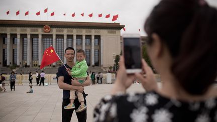 Une famille chinoise sur la place Tiananmen à Pékin. (NICOLAS ASFOURI / AFP)