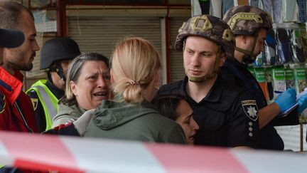 Des habitants de Kharkiv (Ukraine) sous le choc après un nouveau bombardement, le 21 juillet 2022. (SOFIA BOBOK / ANADOLU AGENCY / AFP)