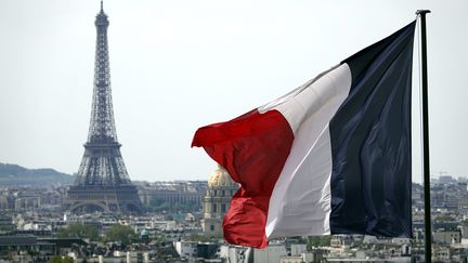 Un drapeau français avec en arrière-plan la Tour Eiffel.&nbsp; (ALEXANDRE MARCHI / MAXPPP)