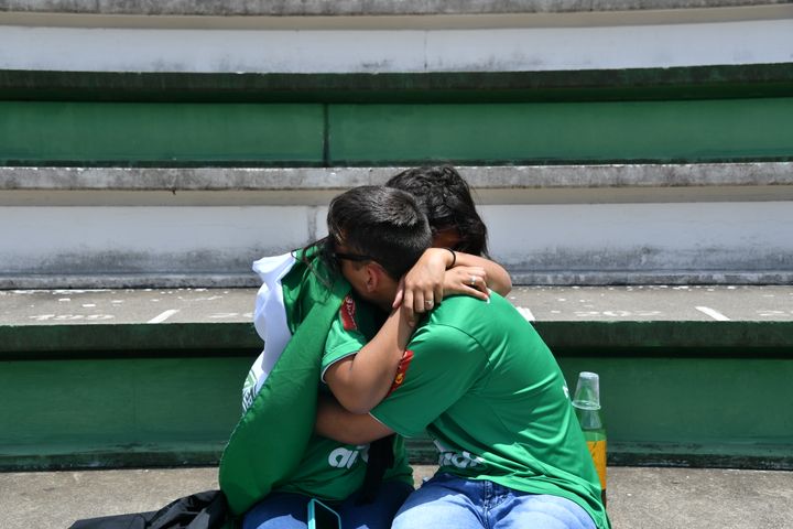 Deux supporters du club martyr rendent hommage aux joueurs décédés dans le club de la ville, le 29 novembre 2016. (NELSON ALMEIDA / AFP)