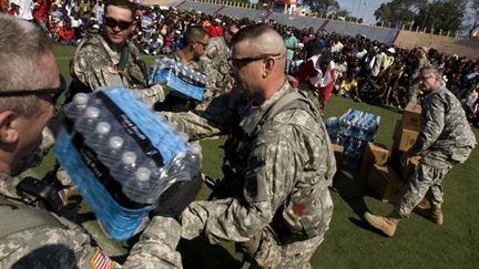 En Haïti, des soldats US apportent de l'eau aux réfugiés dans Port-au-Prince (20/01/2010) (AFP/LOGAN ABASSI)