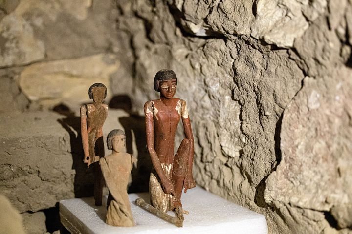 Une statuette et d'autre objets manufacturés photographiés dans la tombe d'Iri, l'une des cinq découvertes à Saqqara.&nbsp; (KHALED DESOUKI / AFP)