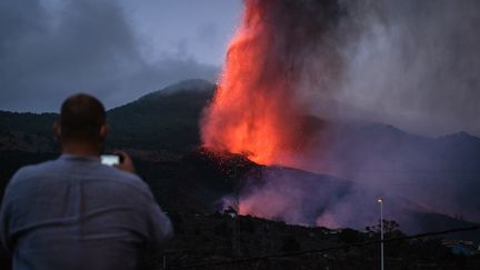 Un riverain immortalise le mont Cumbre Vieja en éruption, depuis Los Llanos de Aridane sur l'île canarienne de La Palma (Espagne),&nbsp; le 20 septembre 2021. (ANDRES GUTIERREZ / ANADOLU AGENCY / AFP)