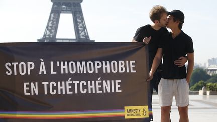 Des militants d'Amnesty international ont déployé une banderole contre les crimes homophobes en Tchétchénie, le 29 mai 2017 à Paris, devant la tour Eiffel.&nbsp; (GEOFFROY VAN DER HASSELT / AFP)