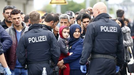 Des policiers surveillent des r&eacute;fugi&eacute;s descendant d'un train, &agrave; la gare de Freilassing (Allemagne), le 14 septembre 2015. (DOMINIC EBENBICHLER / REUTERS)