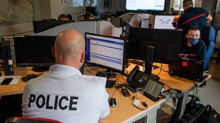 Un policier et des pompiers coopèrent en salle de crise, pour recevoir les appels à la suite de la panne nationale des numéros d'urgence, à Lille, le 3 juin 2021. (MAXPPP)