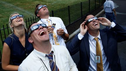 Des journalistes accrédités à la Maison Blanche observent l'éclipse à la résidence présidentielle américaine, le 21 août 2017 à Washington. (YURI GRIPAS / REUTERS)