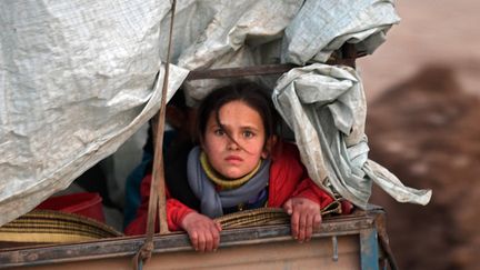 Une fillette syrienne déplacée sur le chemin du camp de Deir al-Ballut, le long de la frontière avec la Turquie, le 19 février 2020. (RAMI AL SAYED / AFP)