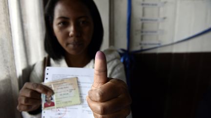 Une Malgache montre son pouce teint&eacute; apr&egrave;s avoir vot&eacute; au premier tour de l'&eacute;lection pr&eacute;sidentielle, le&nbsp;vendredi 25 octobre 2013 &agrave;&nbsp;Antananarivo. (STEPHANE DE SAKUTIN / AFP)