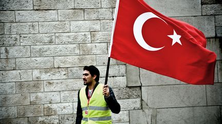 Un homme tient un drapeau turc lors d'une manifestation contre le projet de loi visant &agrave; r&eacute;primer la n&eacute;gation du g&eacute;nocide arm&eacute;nien, le 21 janvier 2012 &agrave; Paris. (NICOLAS MESSYASZ / CITIZENSIDE.COM)