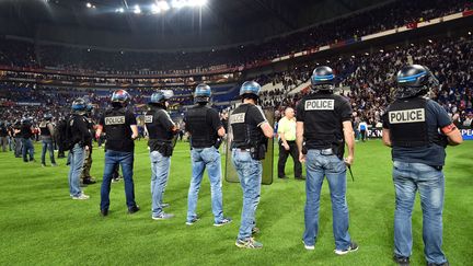 Des membres de la police sur la pelouse du Groupama Stadium. (MUSTAFA YALCIN / ANADOLU AGENCY)