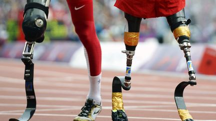 Les coureurs am&eacute;ricains Rudy Garcia-Tolson (D) et Shaquille Vance (G) sur la piste du stade olympique &agrave; l'issue de la finale du 200 m T42, le 1er septembre 2012. (ADRIAN DENNIS / AFP)