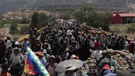 Des centaines de personnes traversent le pont Pirque Parotani lors du barrage routier installé par les partisans d'Evo Morales dans la municipalité de Parotani en Bolivie le 29 octobre 2024. (ALEXIS GOMEZ / ANADOLU / AFP)