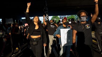 Des gens manifestent dans les rues d'Atlanta avec un panneau "Coupable, coupable, coupable". (MEGAN VARNER / GETTY IMAGES NORTH AMERICA / AFP)