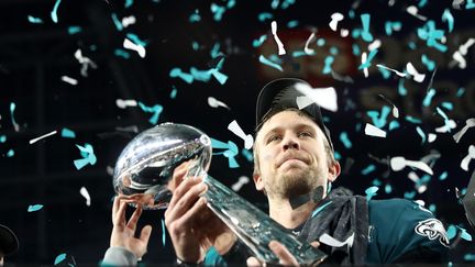 Le quarterback des Philadelphia Eagles, Nick Foles, porte le trophée de vainqueur du Super Bowl, remporté par son équipe le 4 février 2018 à Minneapolis (Minnesota). (ELSA / AFP)