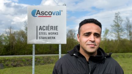 Nacim Bardi, devant un panneau de l'entreprise Ascoval, à Saint-Saulve, dans le Nord. (PHILIPPE HUGUEN / AFP)