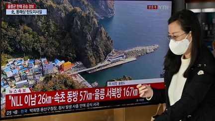 Une femme passe devant un écran de télévision, le 2 novembre 2022 à Séoul (Corée du Sud). (JUNG YEON-JE / AFP)