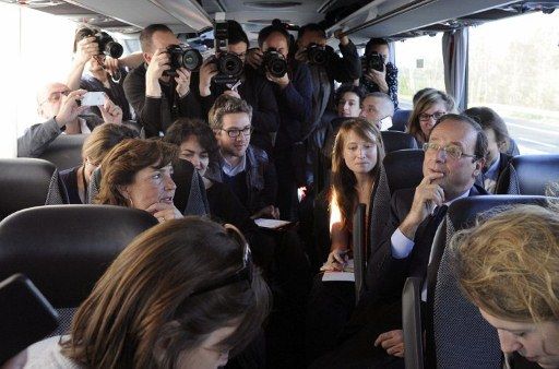 Dans un car pour Clermont, François Hollande livre ses impressions aux journalistes qui le suivent. (Yoan Valat/AFP)