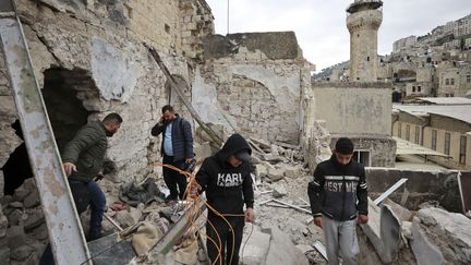 Des hommes palestiniens vérifient une maison démolie lors d'un raid de l'armée israélienne dans la vieille ville de Naplouse la veille, le 23 février 2023. (ZAIN JAAFAR / AFP)