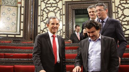 Thierry Mariani (à g.), Nicolas Dhuicq (à d.) et Jean Lassalle (en arrière-plan) au Parlement syrien à Damas, le 12 novembre 2015. (LOUAI BESHARA / AFP)