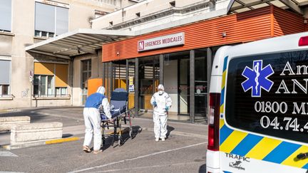 Deux ambulanciers en combinaison de protection poussent un brancard vide devant les urgences&nbsp;en France, le 21 mars 2020. (NICOLAS BEAUMONT / LE PICTORIUM / MAXPPP)