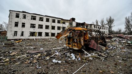 Un bus rouillé à l'extérieur et un gymnase en ruines à Orikhiv, dans la région de Zaporizhzhia (Ukraine), le 12 avril 2023. (DMYTRO SMOLIENKO / NURPHOTO / AFP)