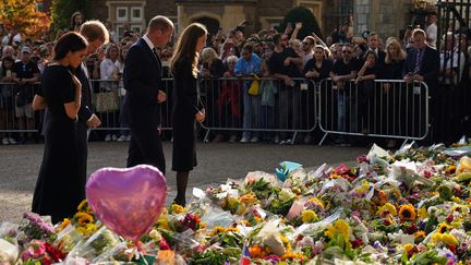 Meghan, duchesse de Sussex, le prince britannique Harry, duc de Sussex, le prince britannique William, prince de Galles et Catherine, princesse de Galles&nbsp;observent les hommages floraux devant le château de Windsor (Royaume-Uni),&nbsp; le 10 septembre 2022. (KIRSTY O'CONNOR / POOL / AFP)