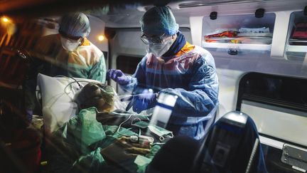 Une personne souffrant du coronavirus est emmenée dans une ambulance. Photo d'illustration. (LUCAS BARIOULET / AFP)