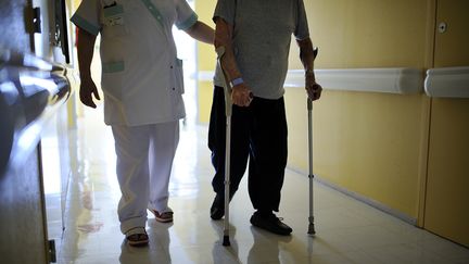 Un infirmier aide un patient dans un CHU de Maine-et-Loire, le 23 octobre 2013. (JEAN-SEBASTIEN EVRARD / AFP)