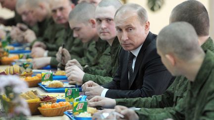 Vladimir Poutine, alors Premier ministre,&nbsp;s'entretient avec des soldats lors d'une visite à la brigade d'infanterie motorisée Taman à Moscou (Russie), le 22 février 2012. (ALEXEI NIKOLSKY / RIA NOVOSTI / AFP)