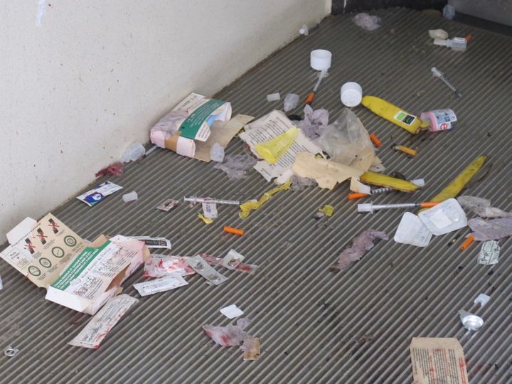 Des seringues usagées et des déchets jonchent le sol des toilettes publiques de la rue Ambroise-Paré, à Paris, le 25 juillet 2017. (MARIE-VIOLETTE BERNARD / FRANCEINFO)